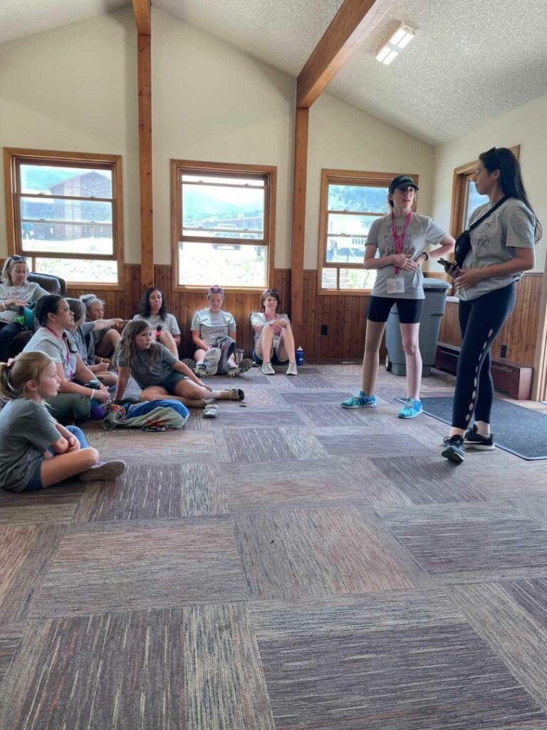 Alexa and Jenna speak to a group of campers about their experiences growing up with lymphedema.
