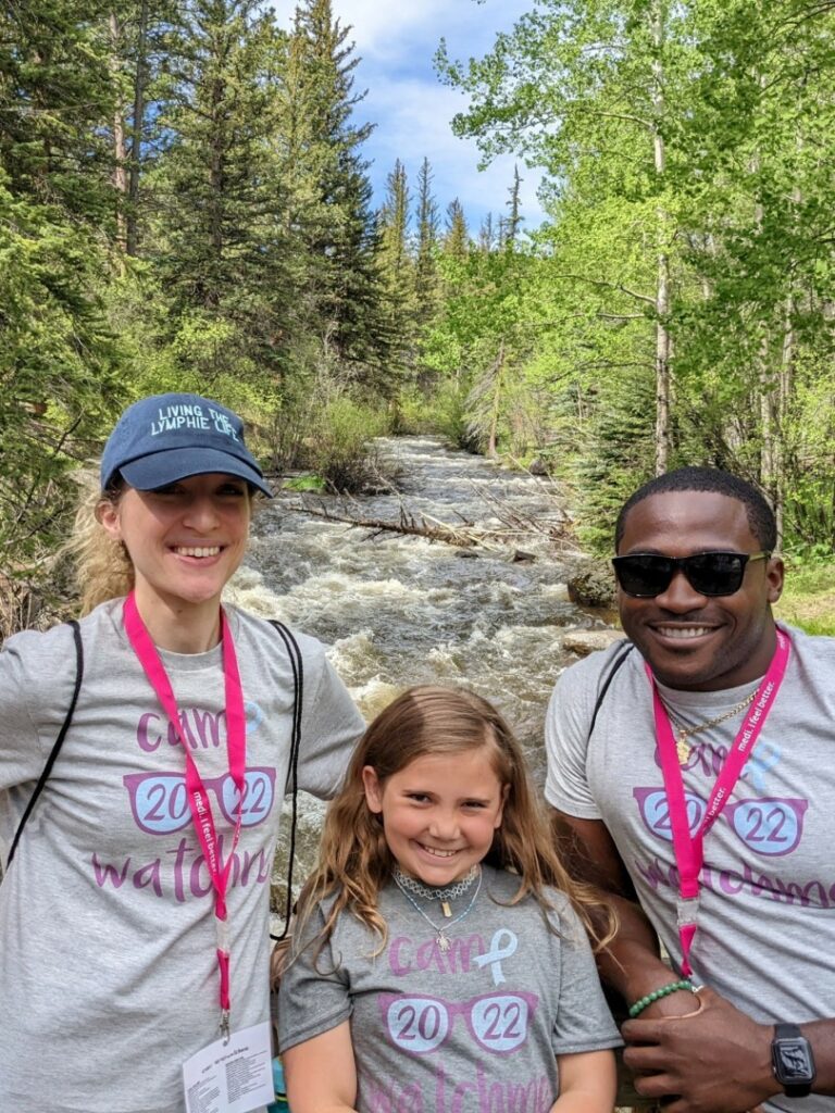 Alexa, Ally, and Dominique pose together in front of a rushing river.